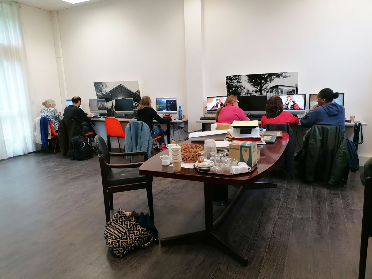 Une salle avec des stagiaires utilisant des ordinateurs. Sur une table, de la vaisselle.