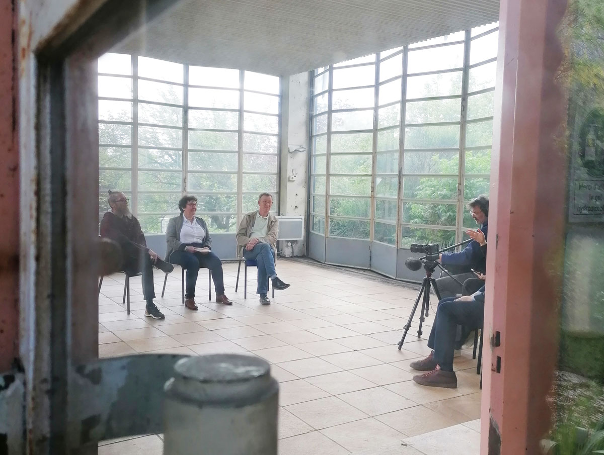 Trois personnes assises dans un pavillon de l'école de plein air.